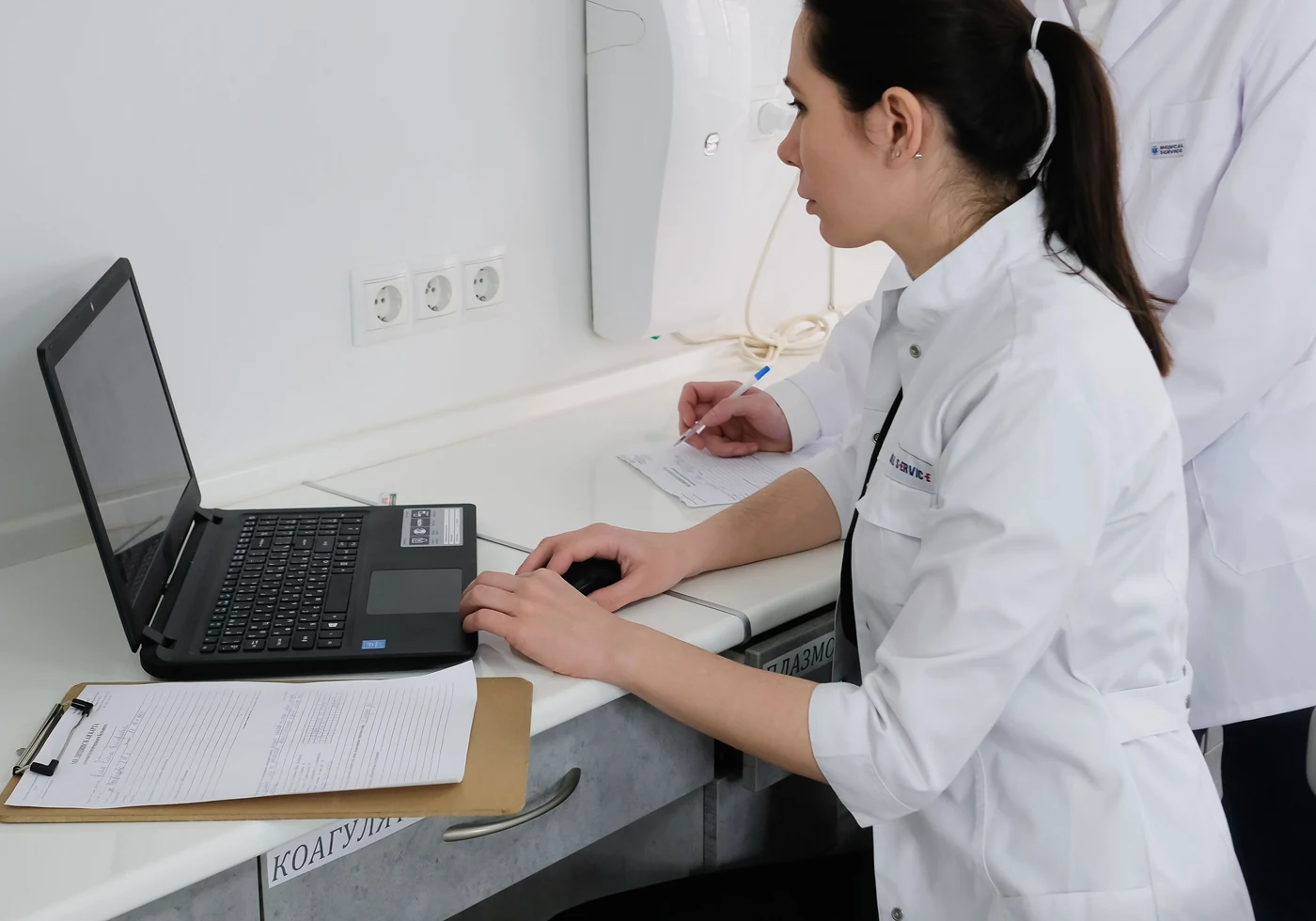 Medical professionals reviewing information on a laptop in a clinical setting